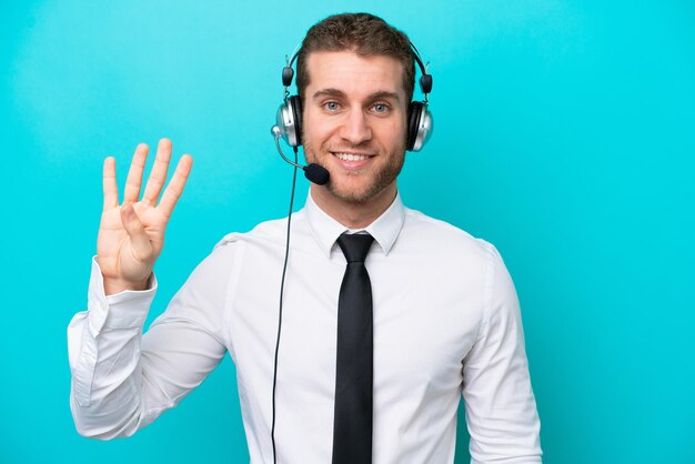 Telemarketer kaukasischer Mann, der mit einem Headset arbeitet, isoliert auf blauem Hintergrund, glücklich und vier mit den Fingern zählend