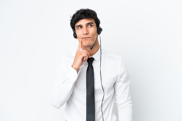 Telemarketer-Mann, der mit einem Headset arbeitet, das auf weißem Hintergrund isoliert ist und eine Idee denkt, während er nach oben schaut