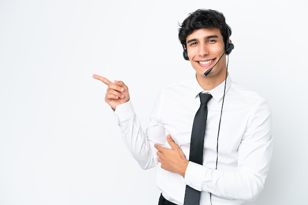 Telemarketer-Mann, der mit einem Headset arbeitet, das auf weißem Hintergrund isoliert ist und mit dem Finger zur Seite zeigt