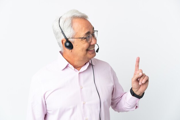 Telemarketer Mann mittleren Alters, der mit einem Headset arbeitet, das auf weißem Hintergrund isoliert ist und auf eine großartige Idee hinweist