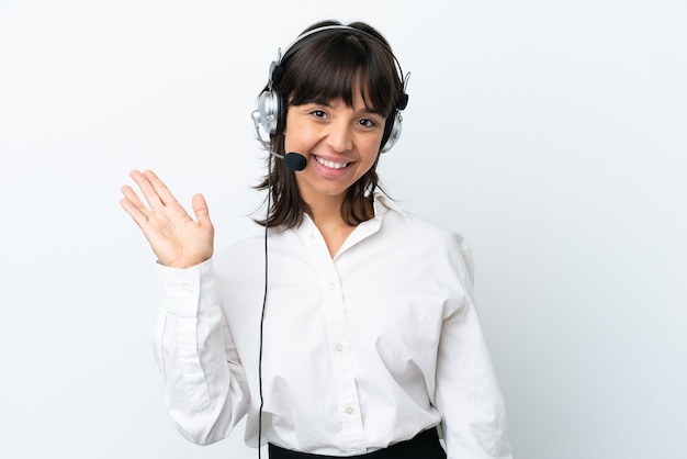 Telemarketer-Mischlingsfrau, die mit einem Headset arbeitet, das auf weißem Hintergrund isoliert ist und mit der Hand mit glücklichem Ausdruck salutiert