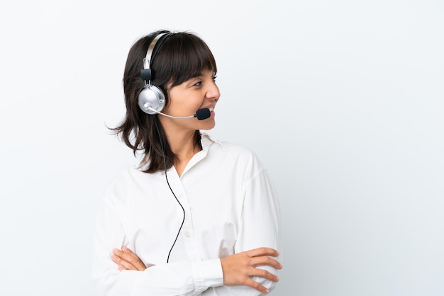 Telemarketer mujer de raza mixta que trabaja con un auricular aislado sobre fondo blanco con los brazos cruzados y feliz