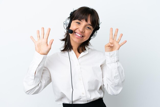 Telemarketer mujer de raza mixta que trabaja con un auricular aislado sobre fondo blanco contando nueve con los dedos