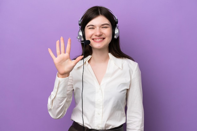 Telemarketer mujer rusa que trabaja con un auricular aislado sobre fondo púrpura contando cinco con los dedos