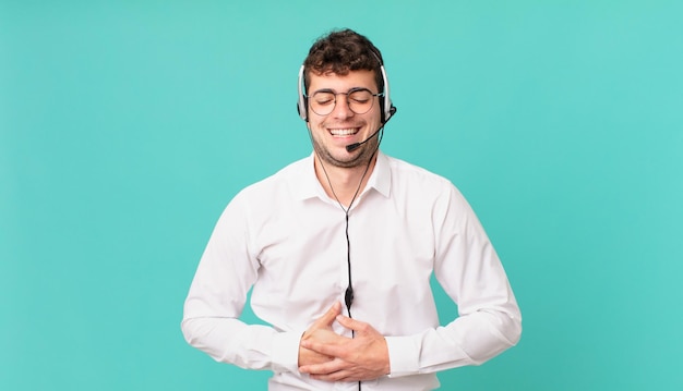 Telemarketer riéndose a carcajadas de una broma hilarante sintiéndose feliz y alegre divirtiéndose