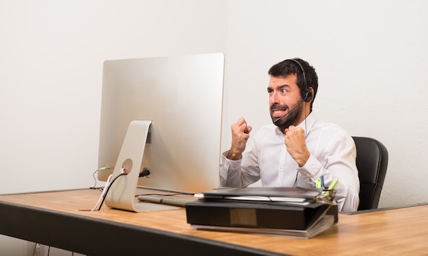 Telemarketermann in einem Büro, das durch eine schlechte Situation frustriert ist