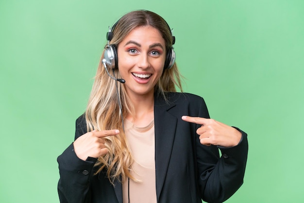 Telemarketing linda mulher uruguaia trabalhando com um fone de ouvido sobre fundo isolado com expressão facial de surpresa