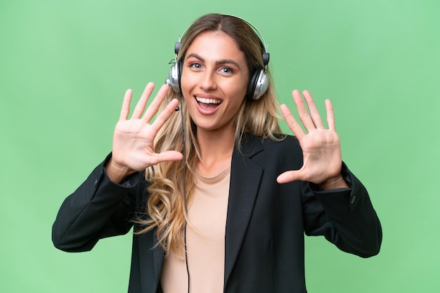 Telemarketing linda mulher uruguaia trabalhando com um fone de ouvido sobre fundo isolado, contando dez com os dedos