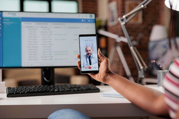 Telemedizin, medizinische Online-Beratung, Frau, die Live-Chat mit Therapeuten hat. Patient spricht mit Arzt über Smartphone-Videoanruf, Hausarzt auf Handy-Bildschirm