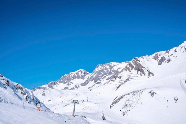 Telesilla en la montaña cubierta de nieve contra el cielo azul claro