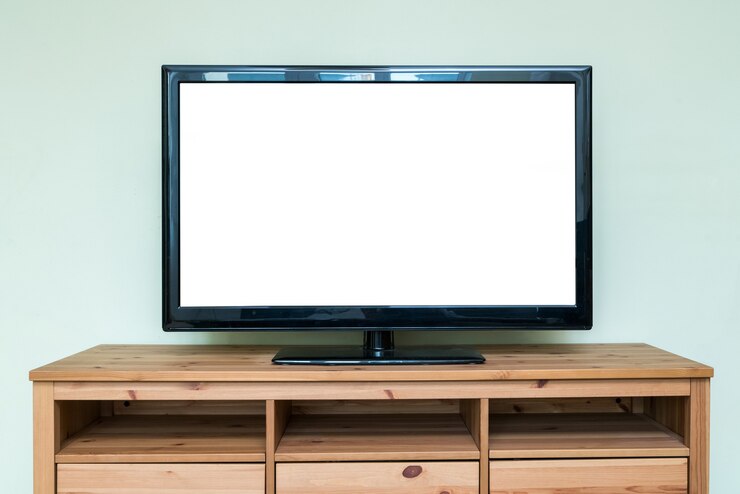 Foto televisión lcd plana sobre mueble de madera marrón en la sala de estar.