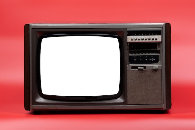 Televisión vintage con pantalla recortada sobre fondo rojo.