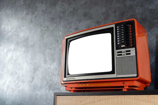 Un televisor retro con una pantalla en blanco se sienta en una habitación un viejo televisor naranja está apagado camino de recorte