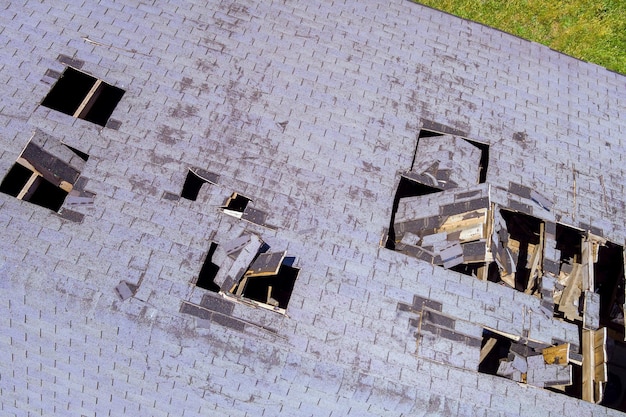 Telhado danificado o buraco de uma casa de telhas em vista aérea superior