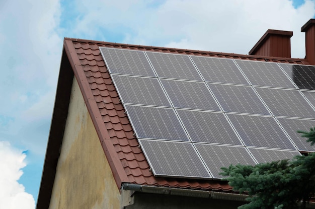 Telhado de casa com módulos fotovoltaicos Casa de fazenda histórica com painéis solares modernos no telhado e na parede
