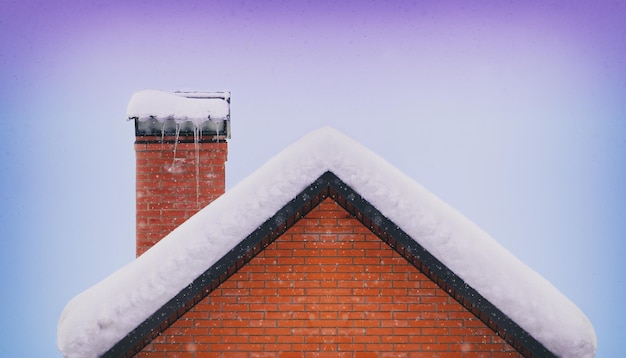 Telhado e chaminé de tijolos cobertos de neve no inverno