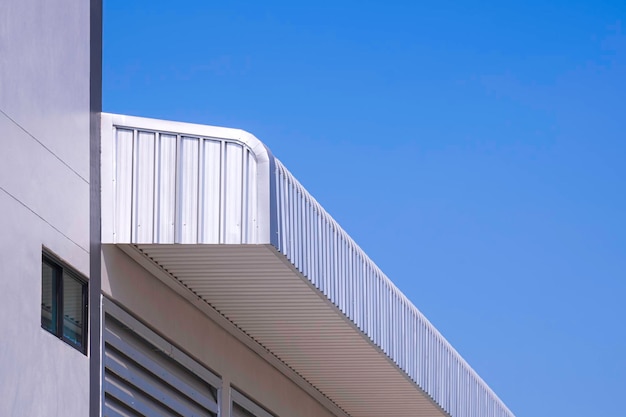 Telhados de aço de alumínio de um novo edifício industrial contra um céu azul claro