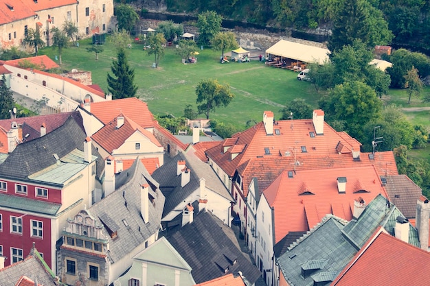 Telhados de casas com telha vermelha e cinza e gramado em uma bela cidade velha vista de cima Toned