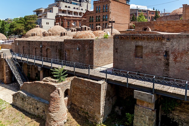 Telhados de tijolos redondos de banhos de enxofre na cidade velha de Tbilisi. Edifícios antigos na cidade velha