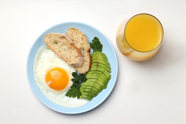 Teller Frühstück und Glas Saft auf weißem Hintergrund