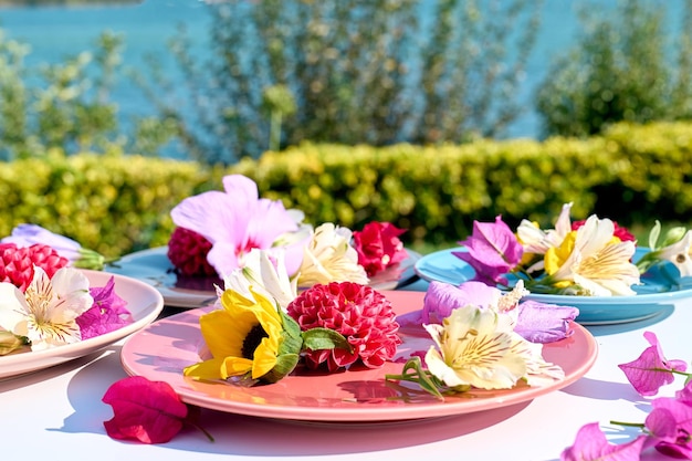 Teller mit Blumen auf einem Tisch im Garten