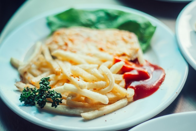 Teller mit Bratkartoffeln und Ketchup auf einem Tablett