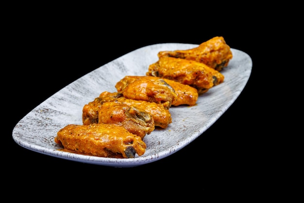 Foto teller mit buffalo chicken wings auf schwarzem hintergrund