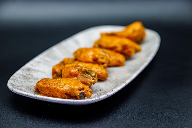 Foto teller mit buffalo chicken wings auf schwarzem hintergrund