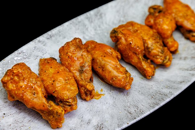 Foto teller mit buffalo chicken wings auf schwarzem hintergrund