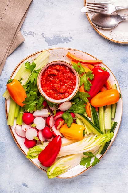 Teller mit frischem rohem Gemüse und Sauce