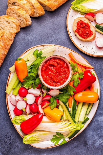 Teller mit frischem rohem Gemüse und Sauce