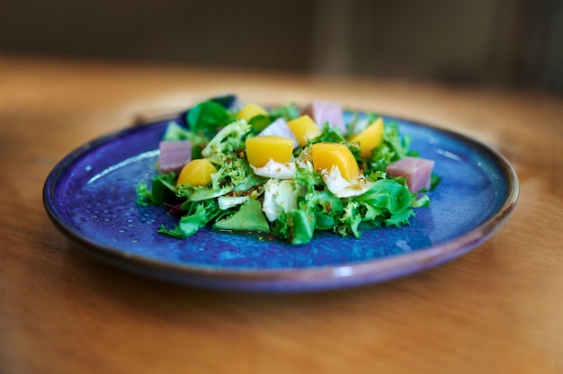 Teller mit frischem Salat mit Pfirsich in Sirup