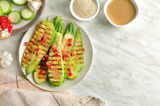 Teller mit gegrilltem Gemüse und leckerem Tahini auf dem Tisch, Draufsicht