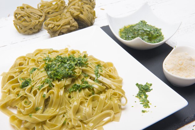 Teller mit italienischen Tagliatele-Nudeln mit geriebenem Käse auf dem Tisch serviert