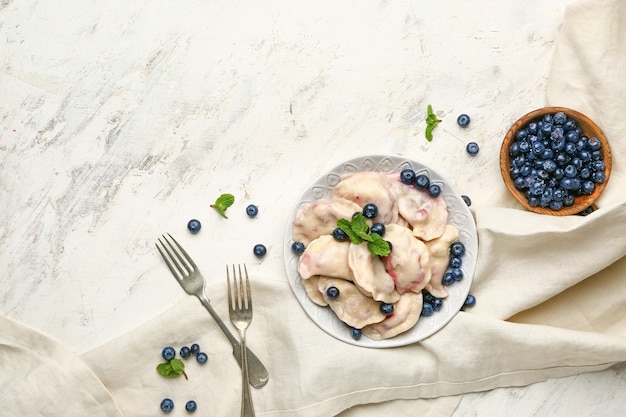 Teller mit leckeren Knödeln und Blaubeeren auf dem Tisch