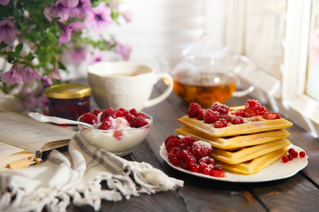 Teller mit leckeren Waffeln auf Holztisch