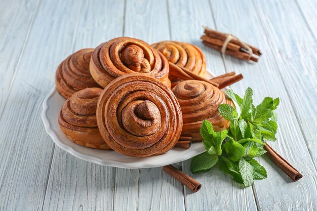 Teller mit leckeren Zimtschnecken auf dem Tisch