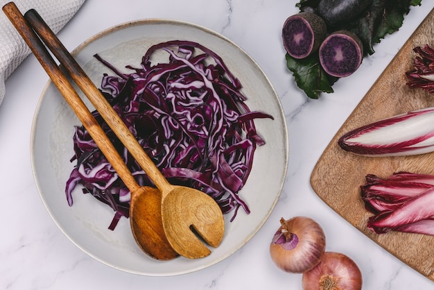 Teller mit lila Rotkohl und lila Kartoffel-Holzlöffel