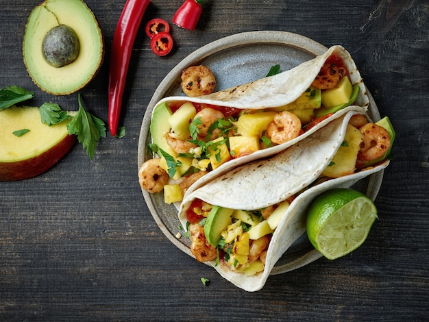 Teller mit mexikanischem Essen Tacos auf schwarzem Holzküchentisch Hintergrund, Ansicht von oben