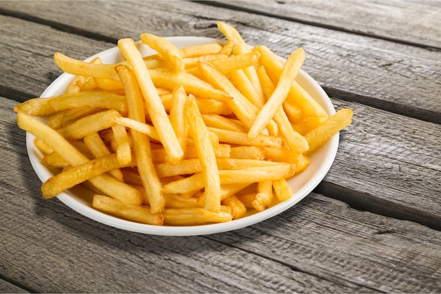 Teller mit Pommes Frites auf Holztisch