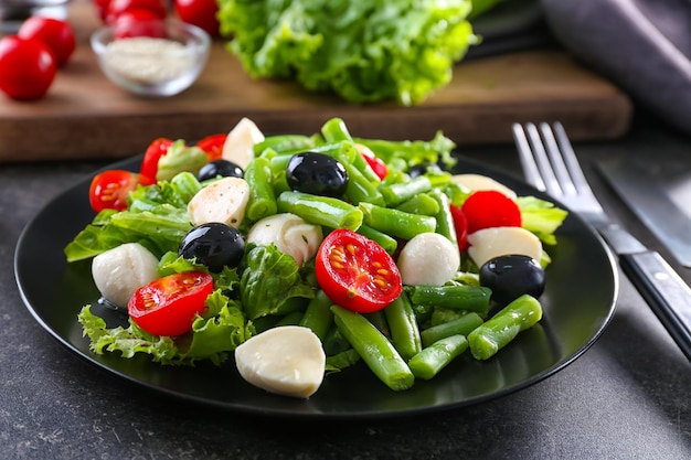 Teller mit Salat und grünen Bohnen auf dem Tisch