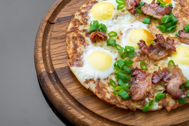 Teller mit Spiegeleiern, Speck, Tomaten und Kartoffelgrillkuchen hautnah