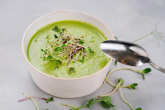 Teller mit Spinat-Creme-Suppe und Gemüse Nahaufnahme