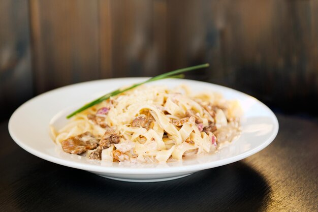 Foto teller mit tagliatelli carbonara italienisches essen in einem rustikalen restaurant. pasta carbonara