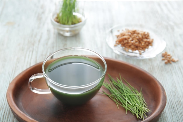 Teller mit Tasse Weizengrassaft auf dem Tisch