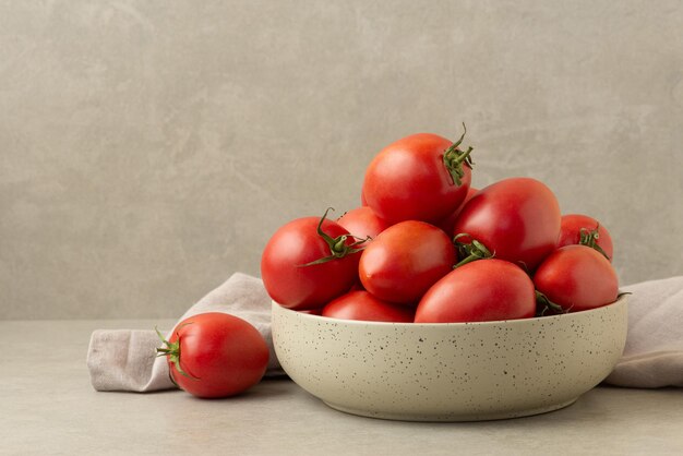 Teller mit Tomaten auf grauem Hintergrund, kulinarischer Hintergrund