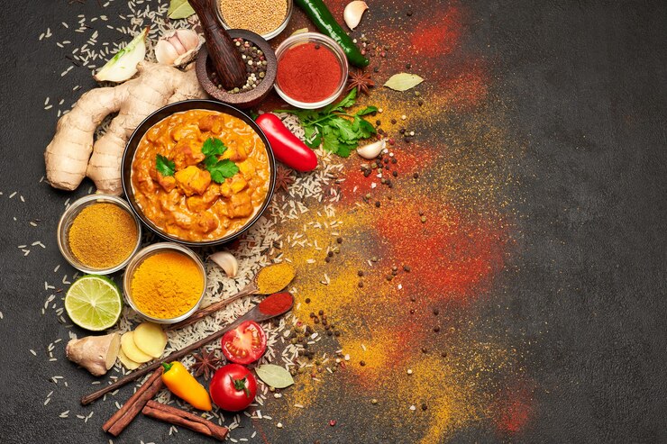 Foto teller mit traditionellem hühnercurry und gewürzen auf dunklem tisch