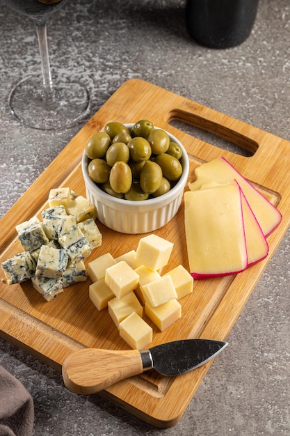 Teller mit verschiedenen Käsesorten mit einem Glas Wein Käseplatte