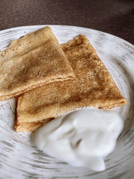 Teller russischer Pfannkuchen mit Sauerrahm