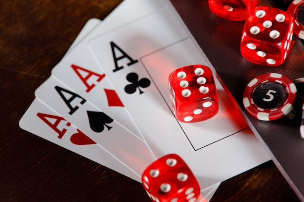 Tema de casino online vermelho jogando fichas e cartas de jogos de dados em uma mesa de madeira